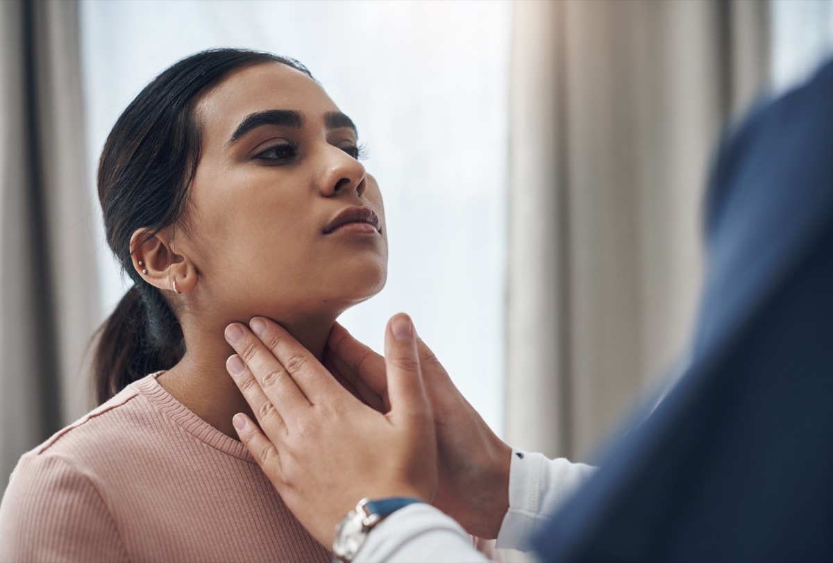 Shot of an unrecognizable doctor feeling a patient's throat in an office