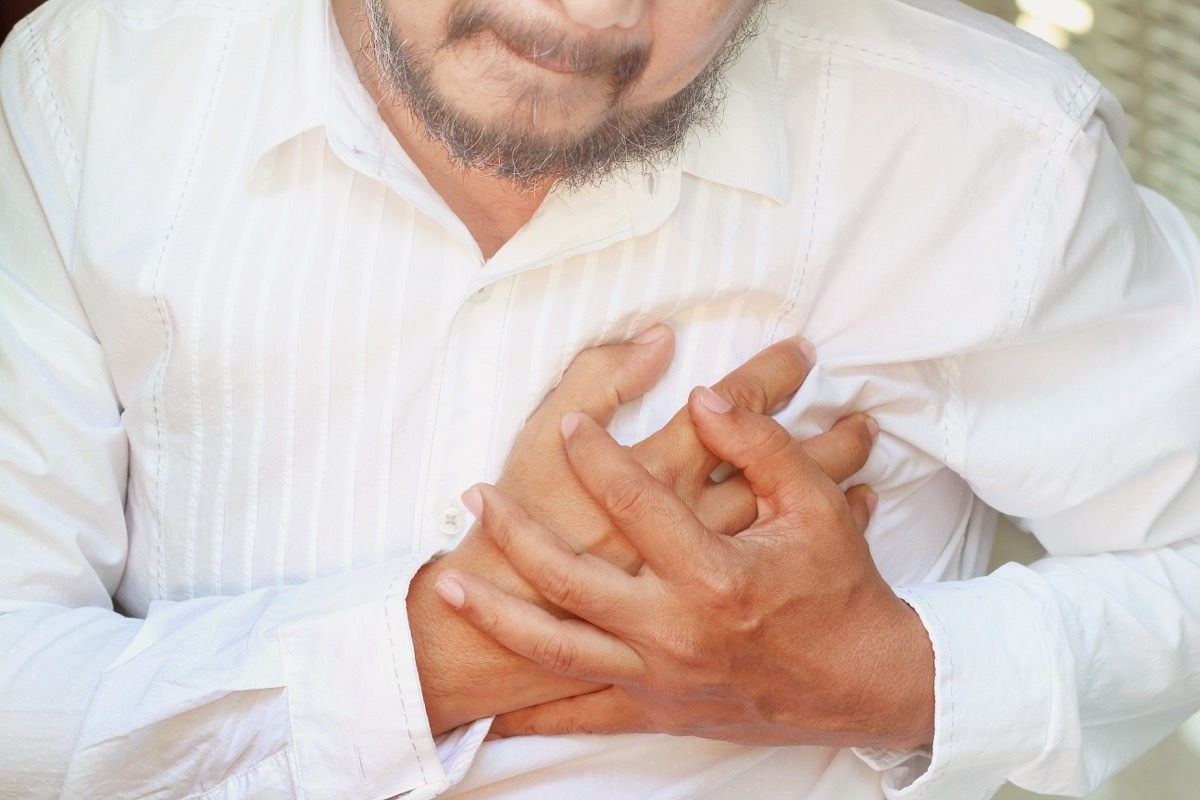 man holding his chest in pain, health questions after 40