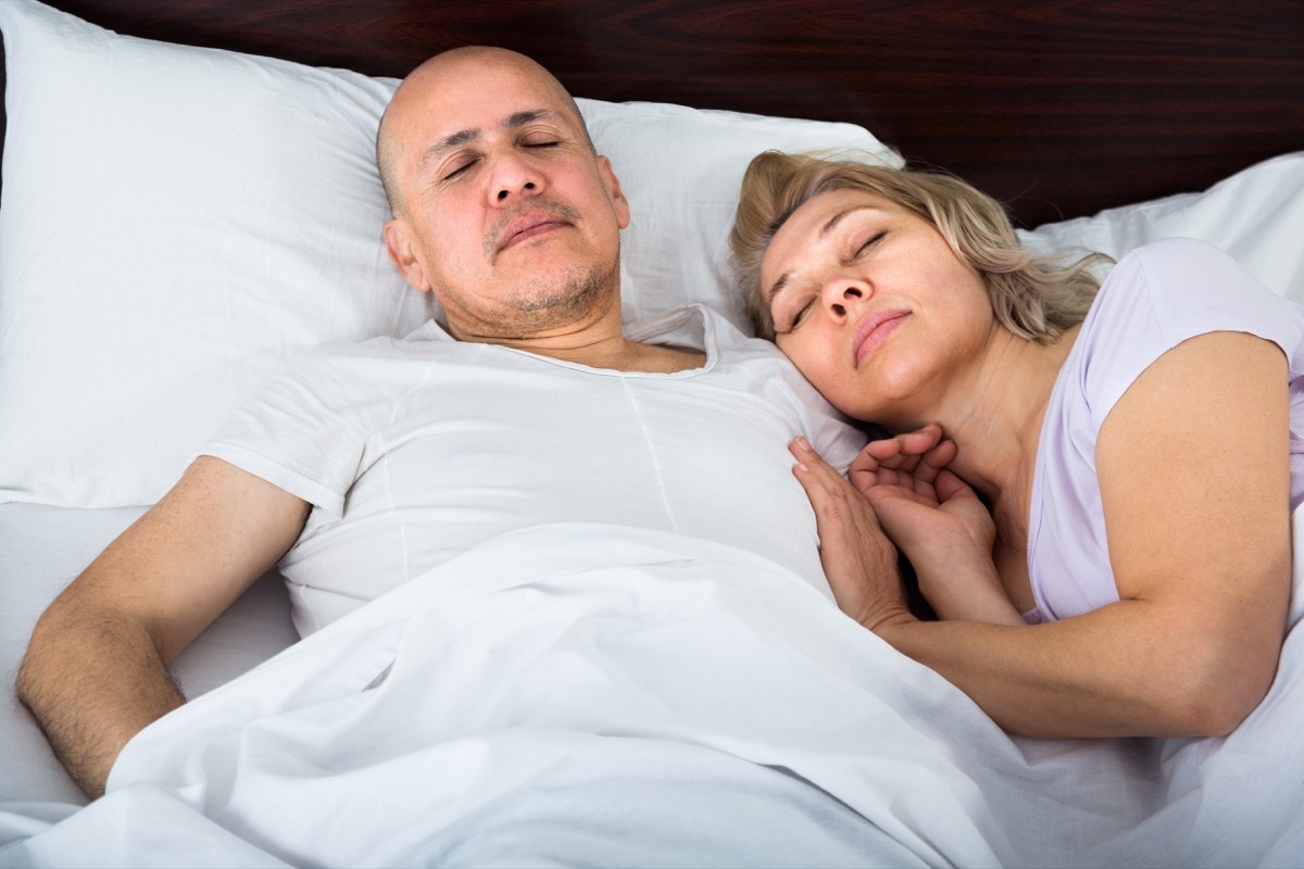 couple sleeping in bed together, smart person habits