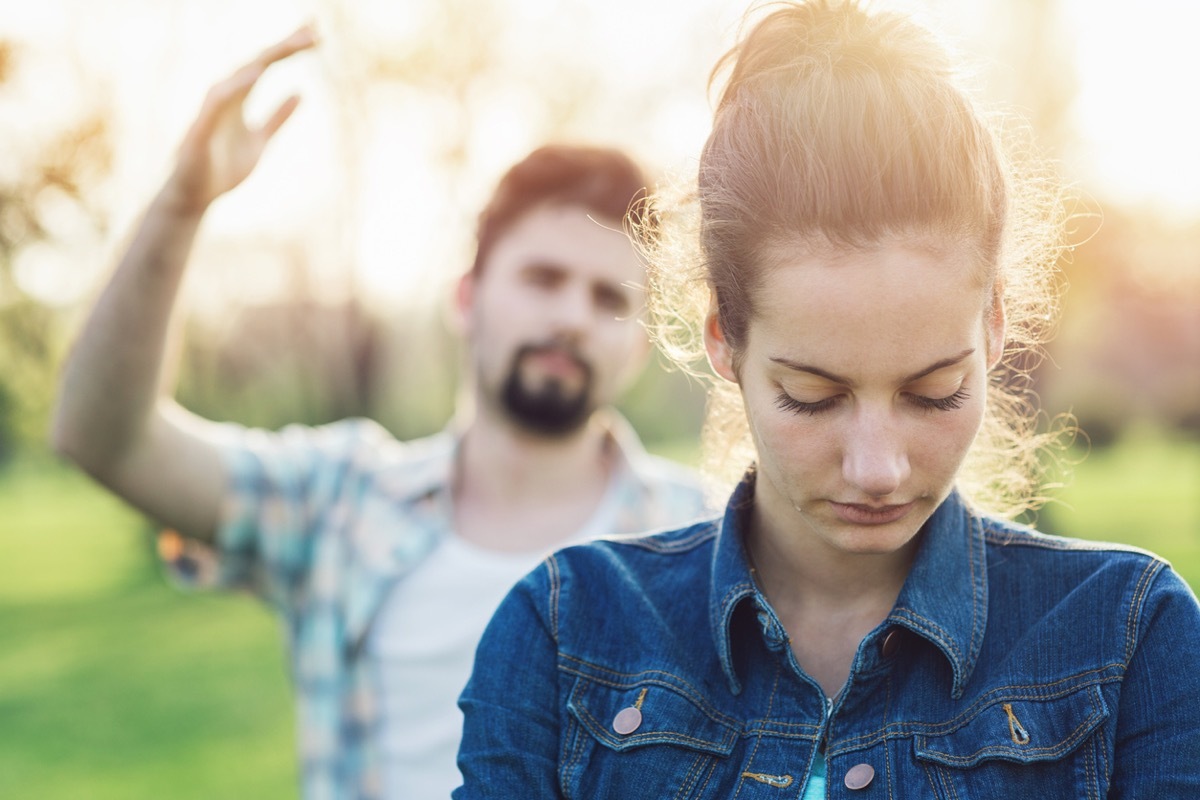 white woman looking sad with white man behind her throwing up his hand in anger