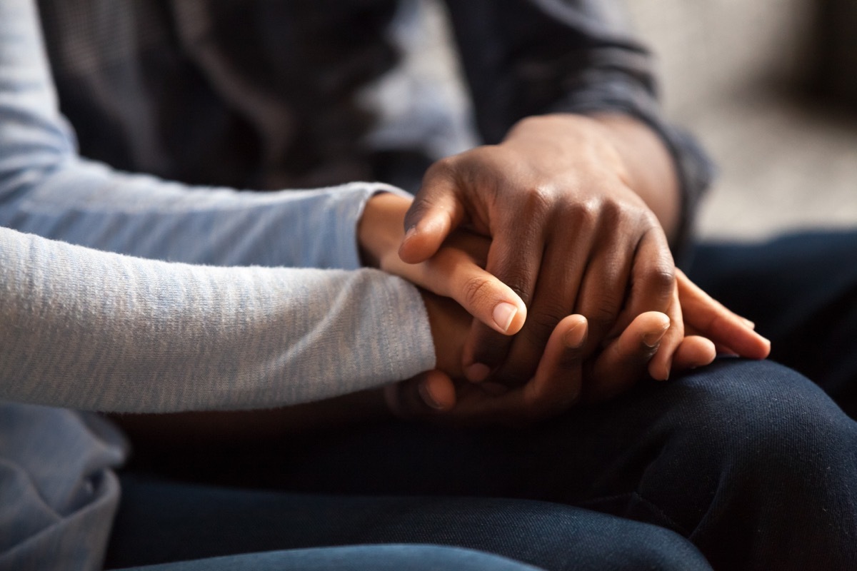 two women holding hands while giving an apology