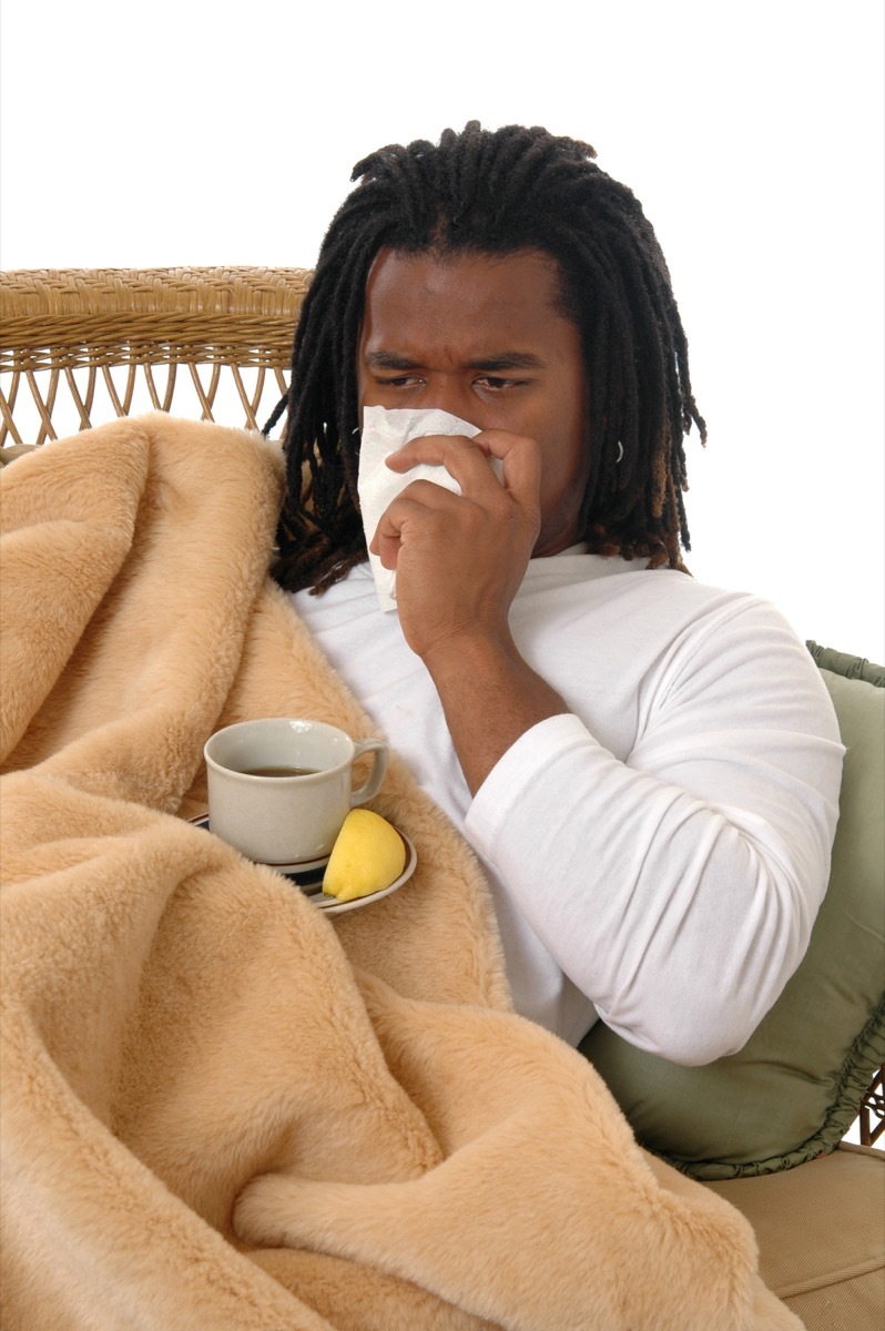 Black man blowing his nose and sneezing