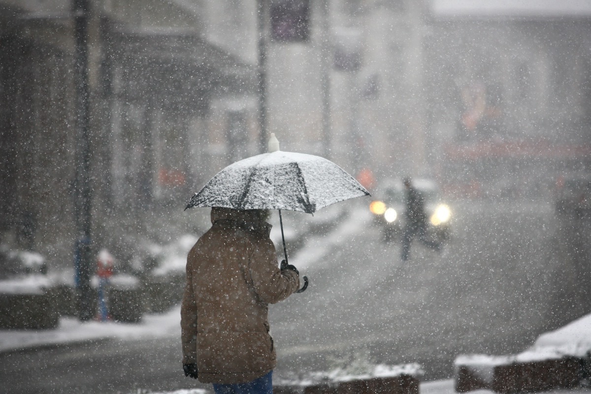 man walking with umbrella in a winter storm