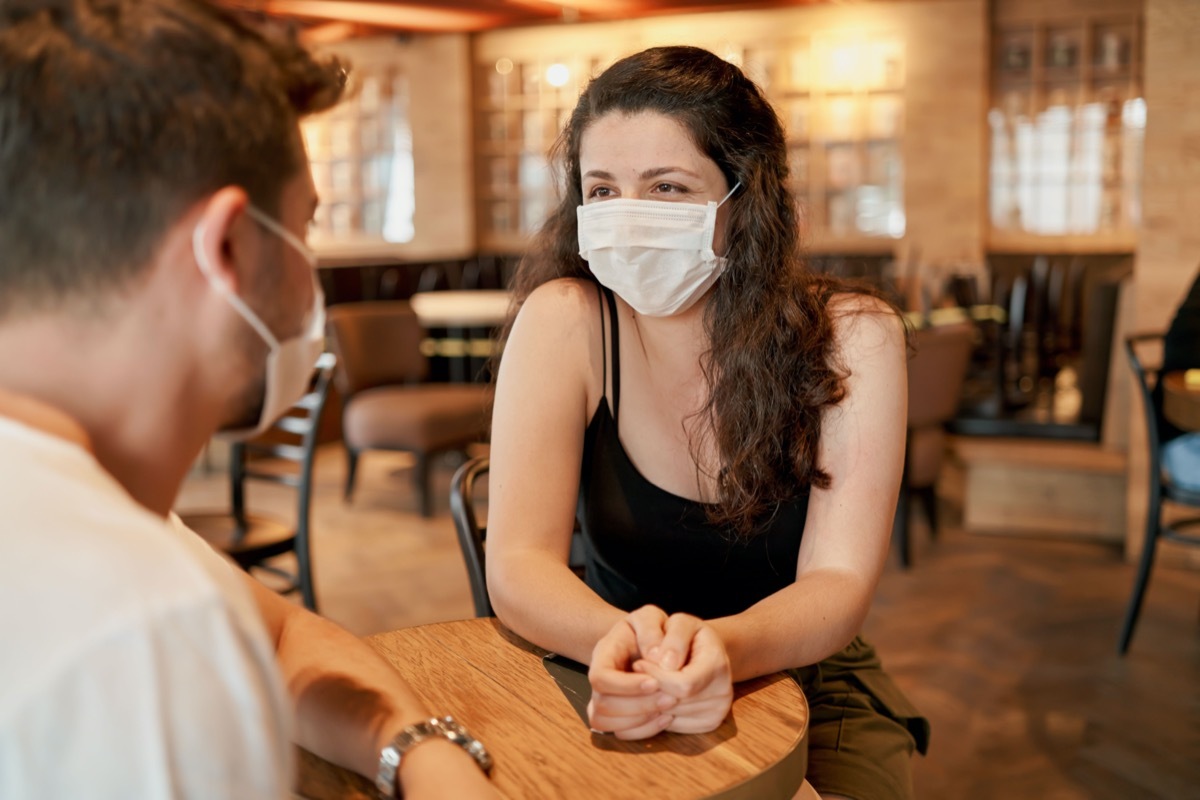 woman and man at restaurant wearing masks