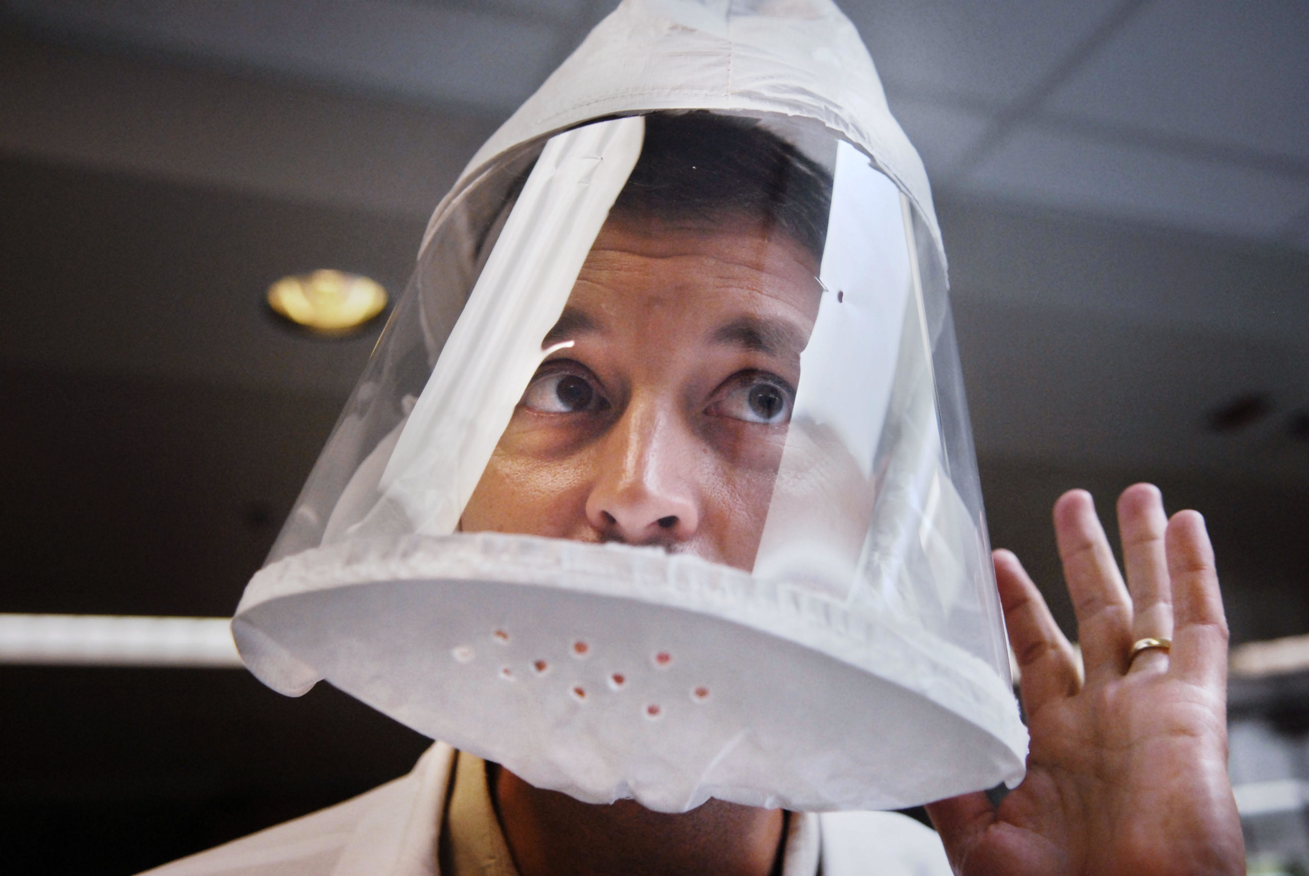 A man listening to colleagues while wearing a powered air purifying respirator