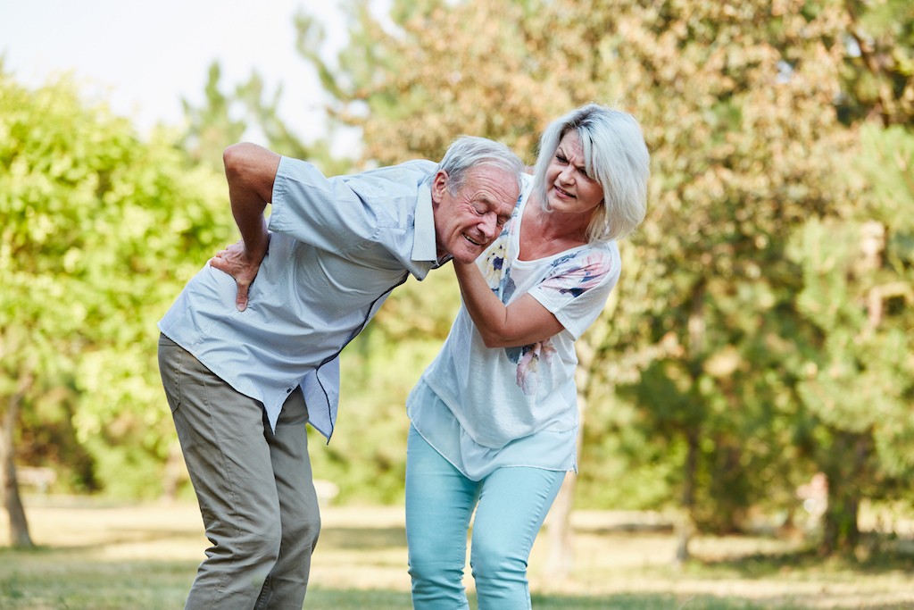 old man suffering from hip and lower back pain getting assistance