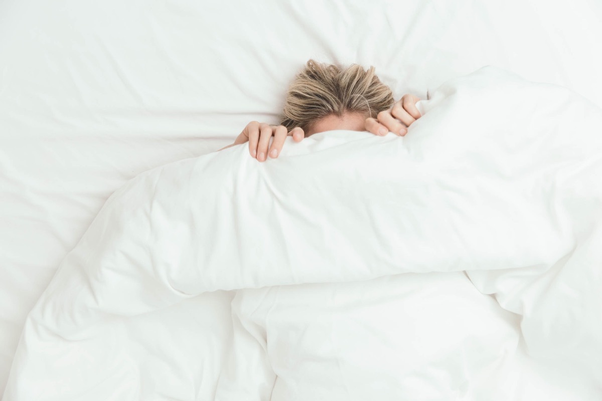 Woman in bed under covers