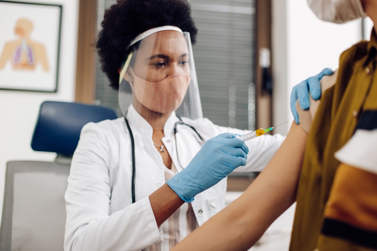 female doctor giving a Covid-19 vaccine to a young woman.