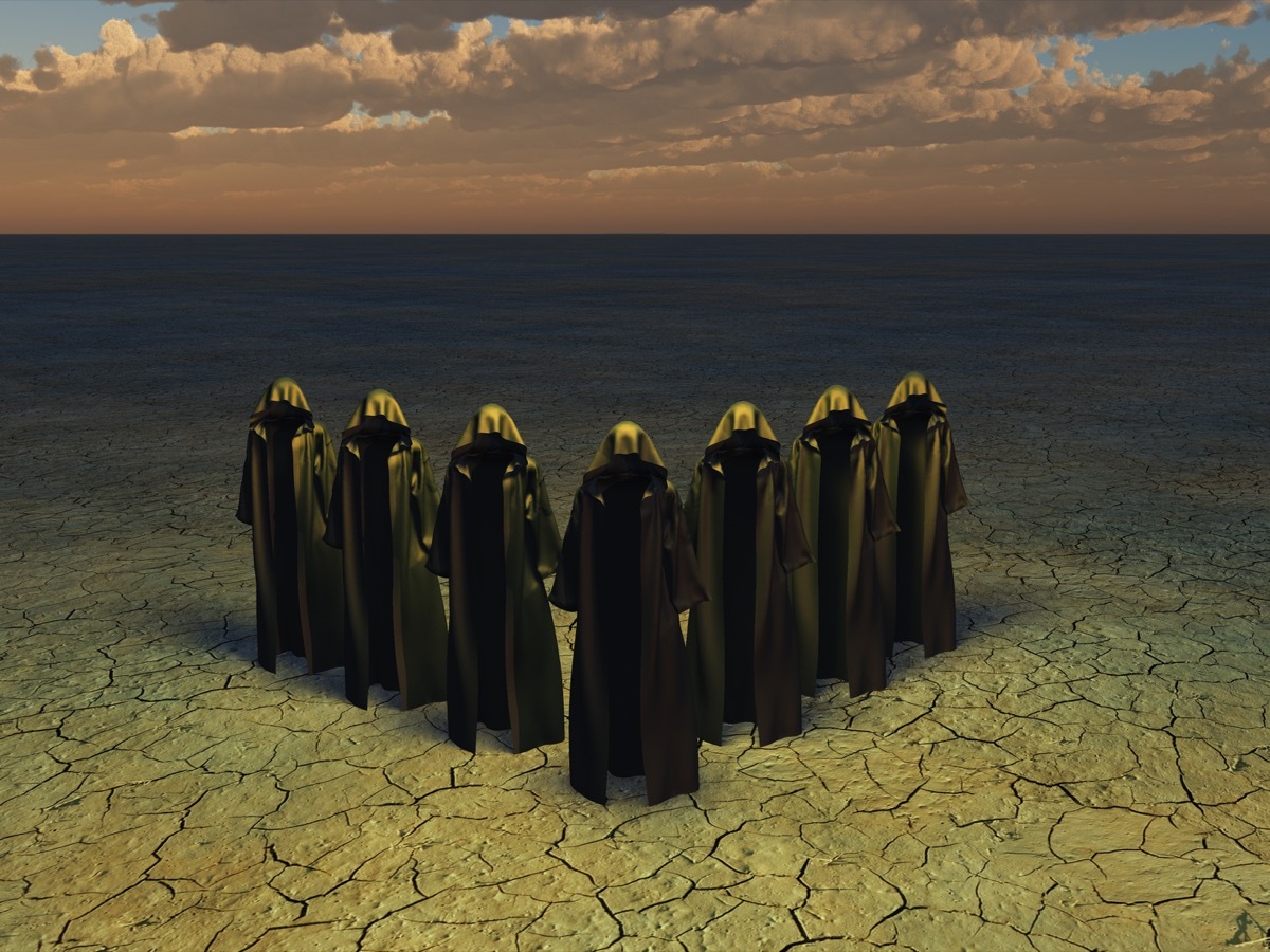 hooded figures on barren landscape