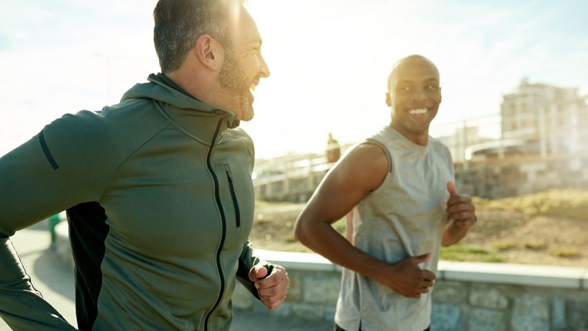 Shot of two sporty men exercising together outdoors