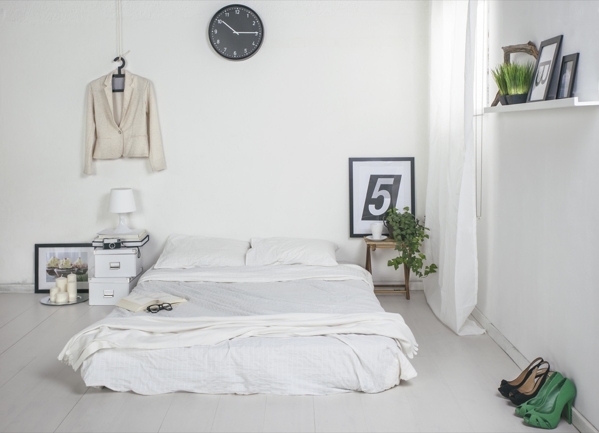 a modern white bedroom with the mattress placed directly on the floor