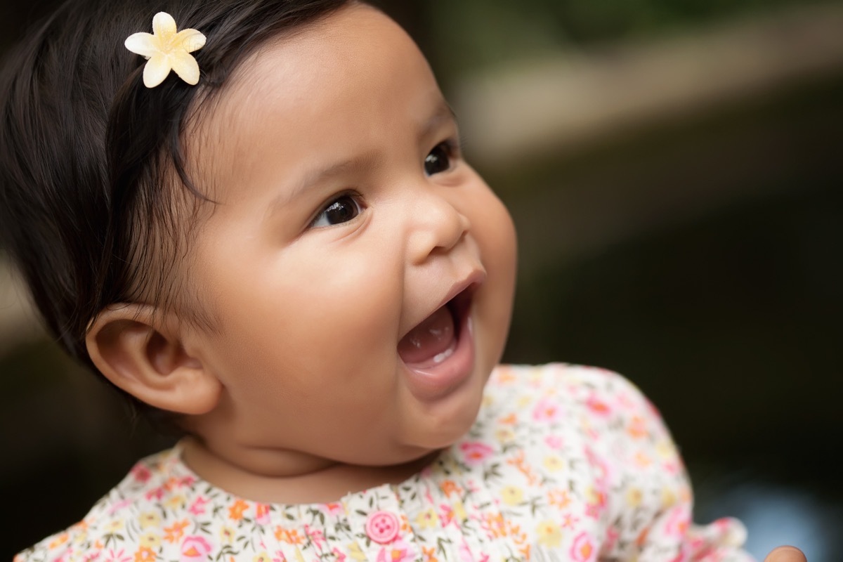 smiling hispanic baby with flower in her hair