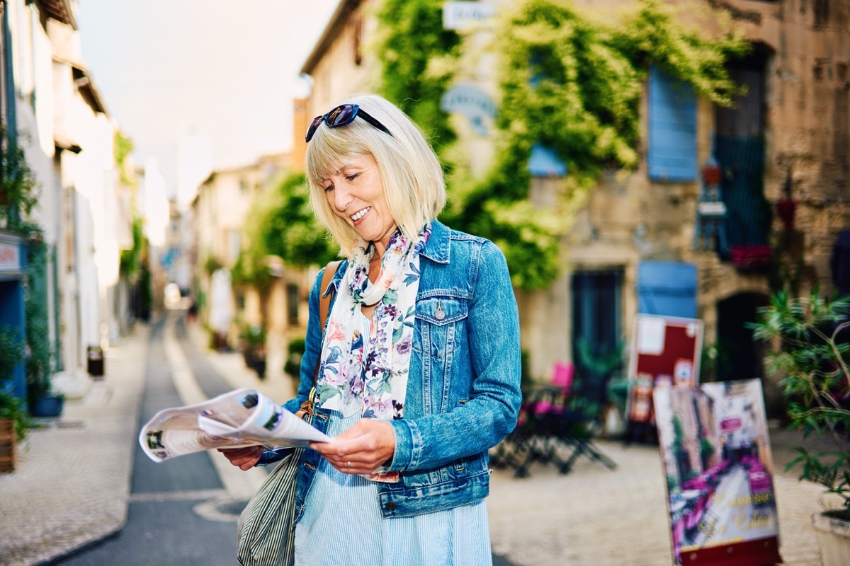 older woman wearing jean jacket while traveling