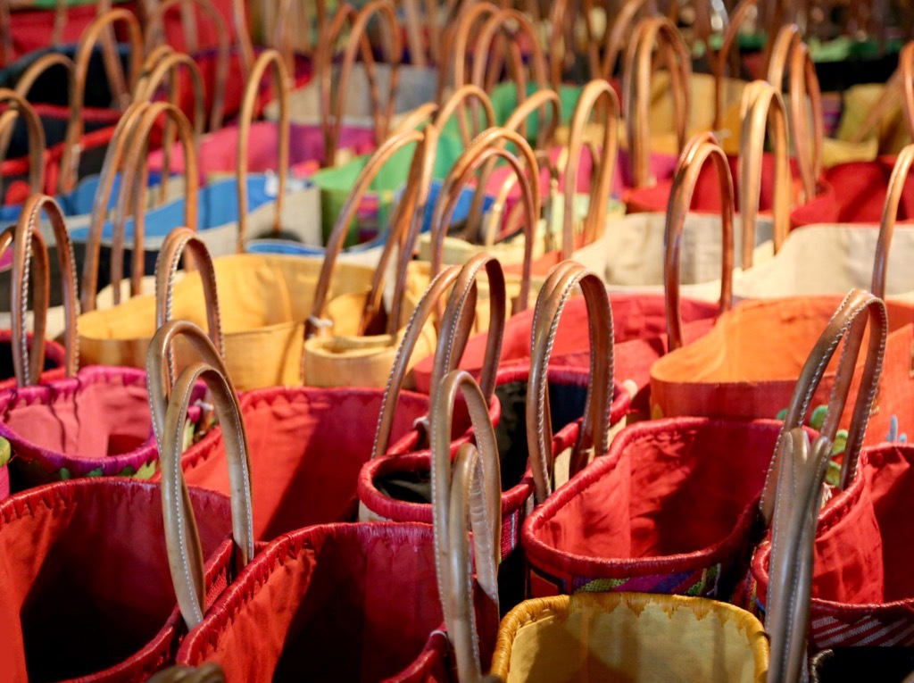 bunch of handbags at a thrift store.