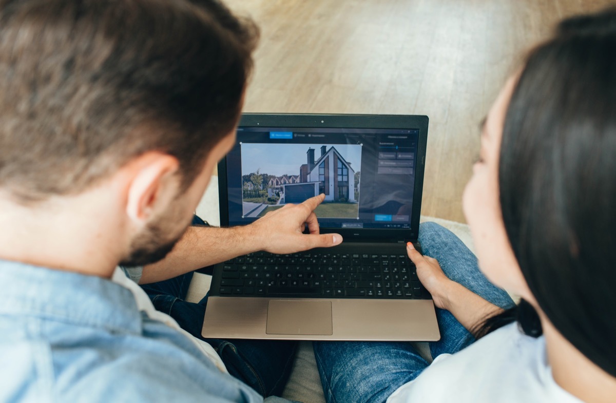 couple choosing new house using laptop. Scrolling the Internet in search of new estate