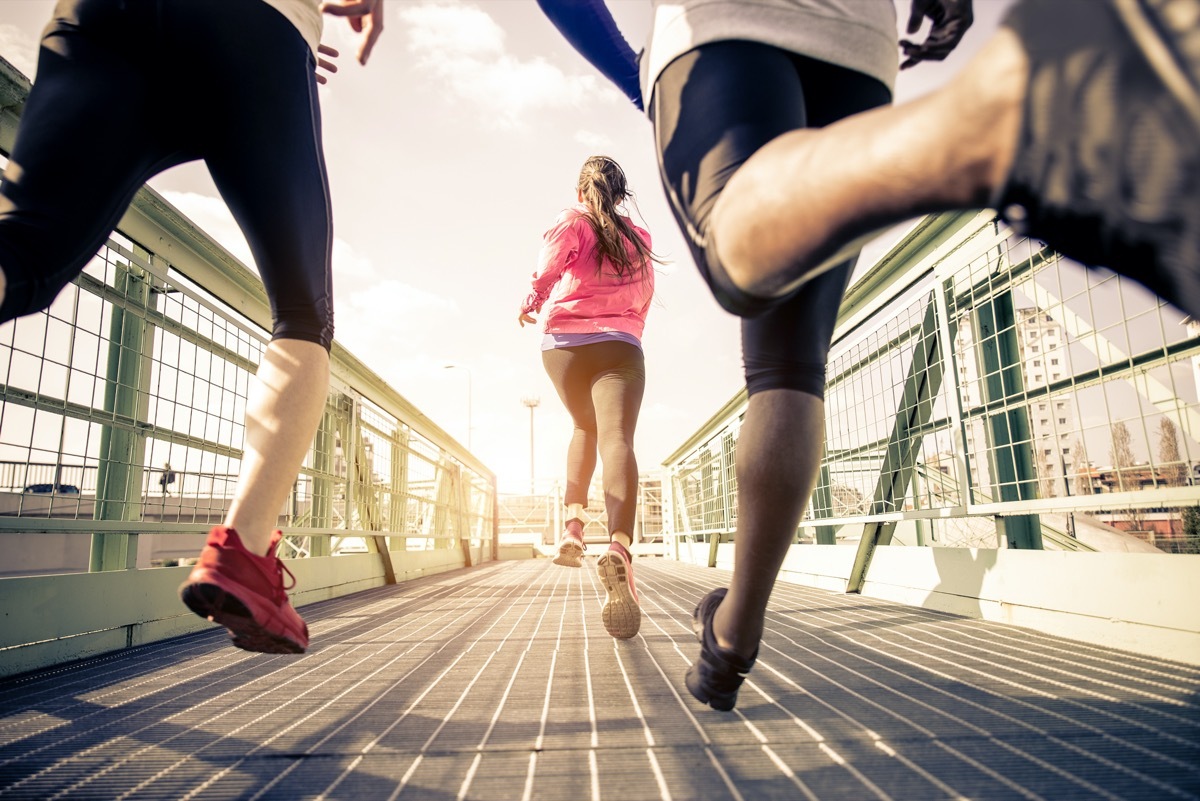 Three runners sprinting outdoors - Sportive people training in a urban area, healthy lifestyle and sport concepts