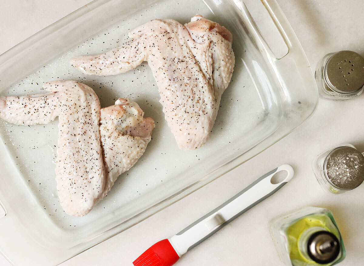 Prepping turkey wings to be baked in the oven with olive oil and seasoning