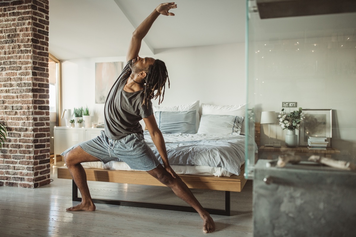 man doing yoga in his home