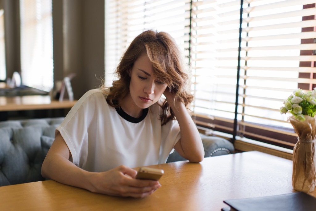 woman texting on her phone, ways your body changes after 40