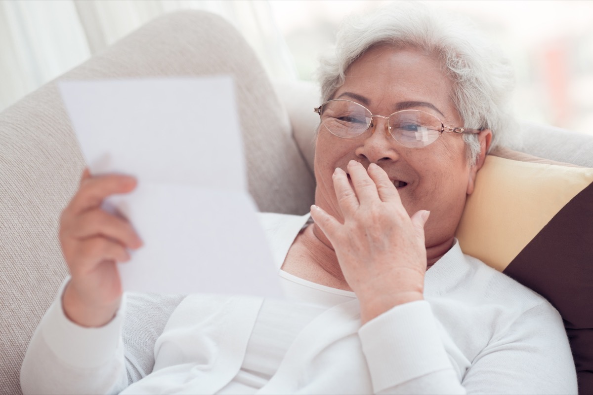 a woman laughing while reading funny love letters for her