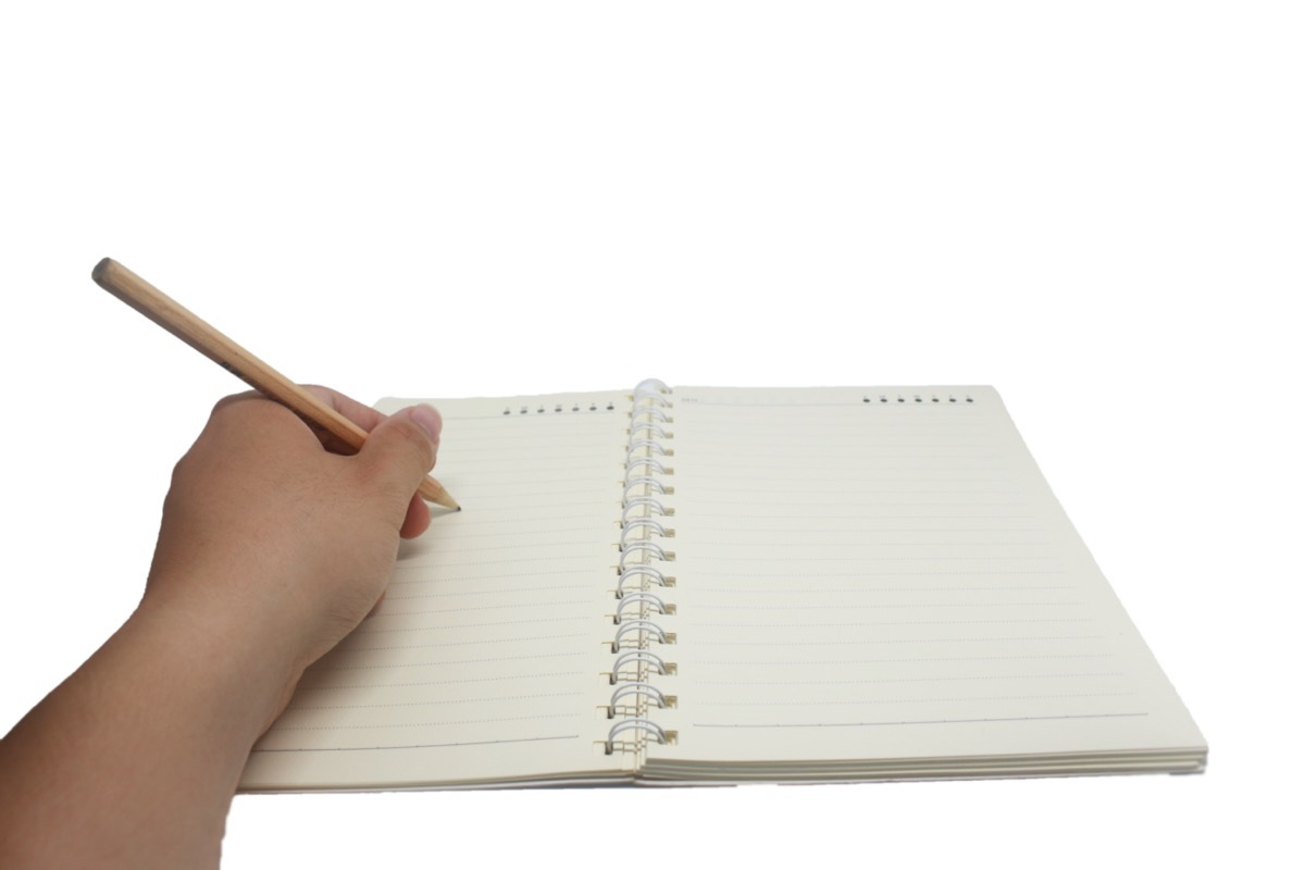 Left handed person writing in notebook