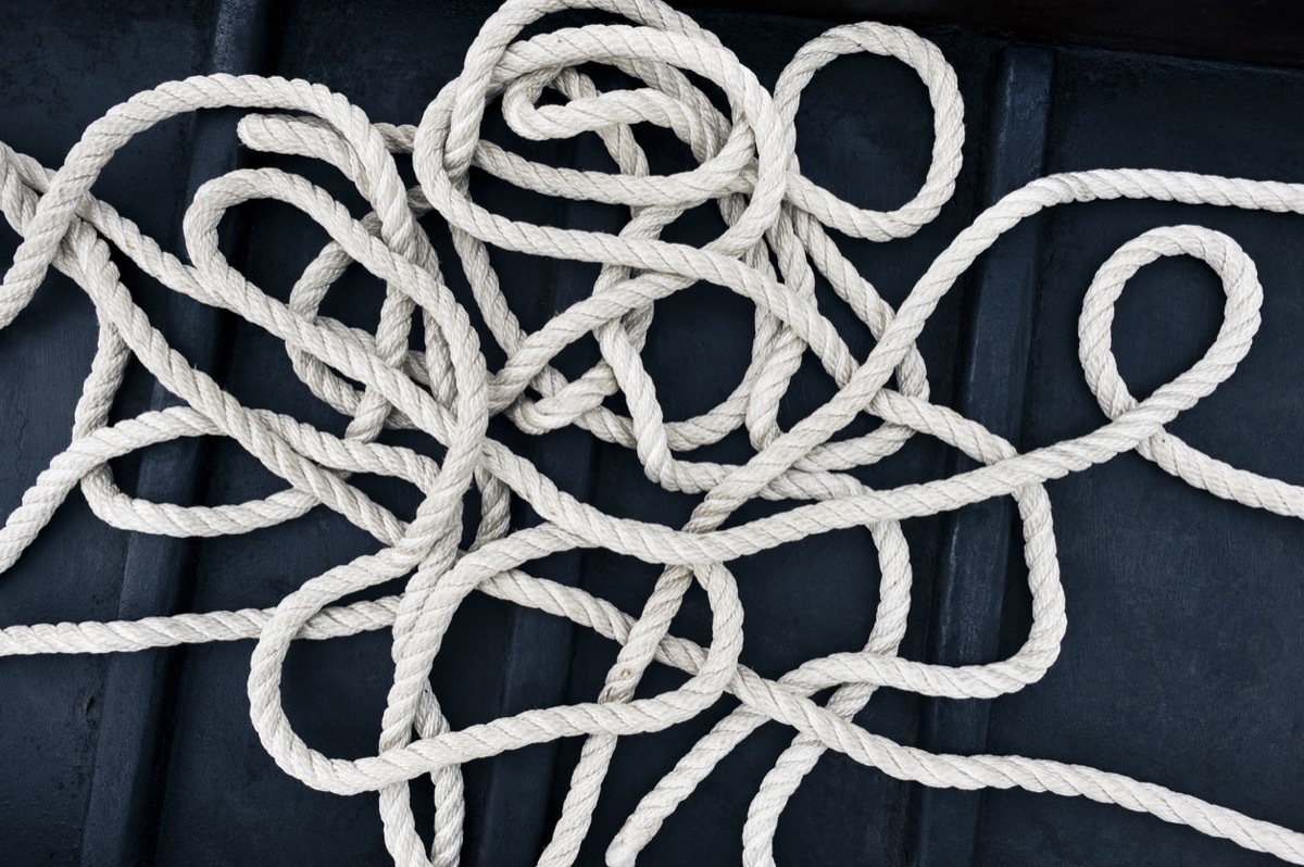 a tangle of white nylon rope on a dark boarding ramp left by some untidy boatsman.