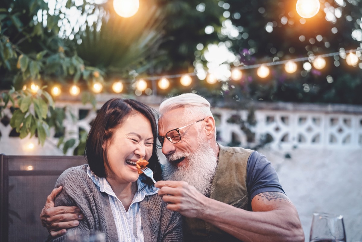 Man feeding woman and woman laughing on a date