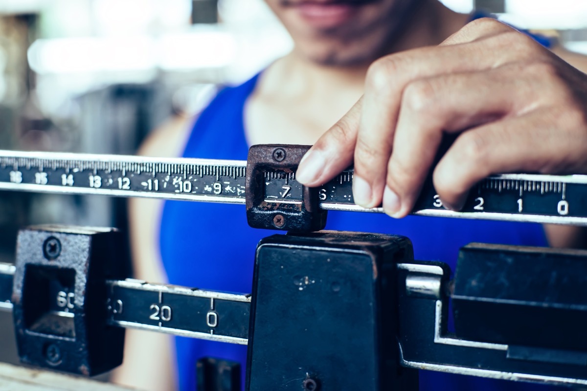 Man weighing himself on scale