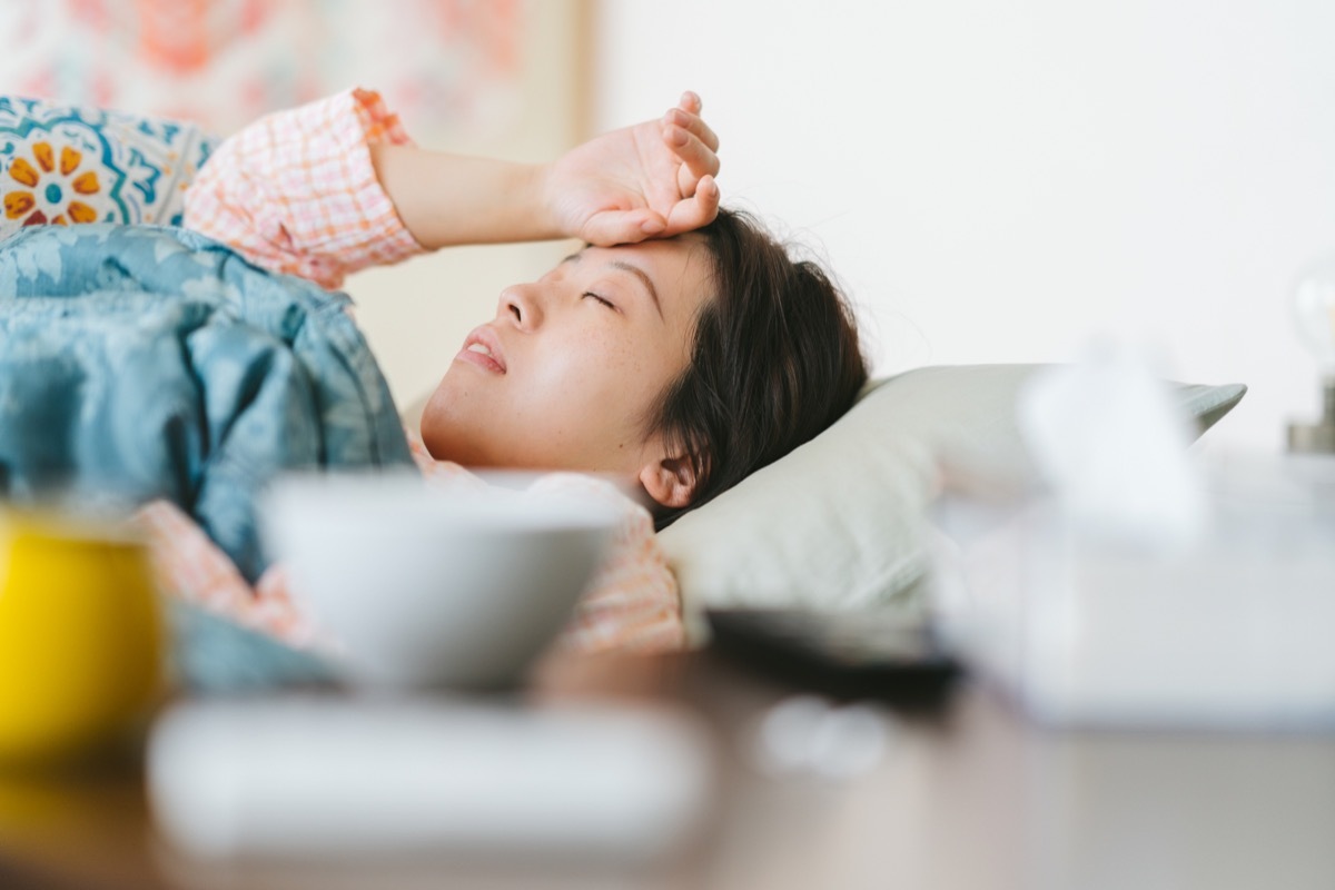 A women is feeling sick and sleeping on a sofa at home.