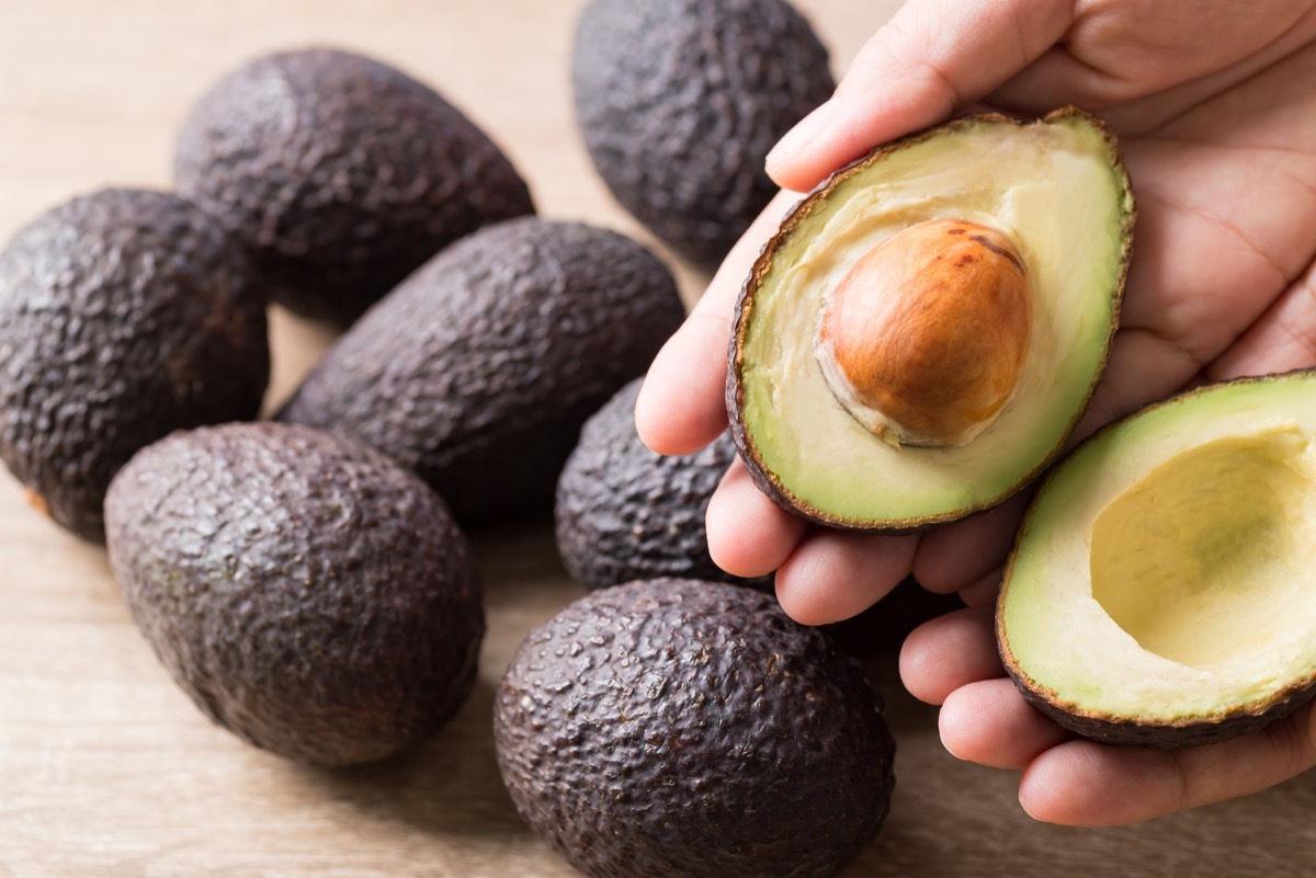 Ripe hass avocado fruit in hand ready to eating, Healthy fruit