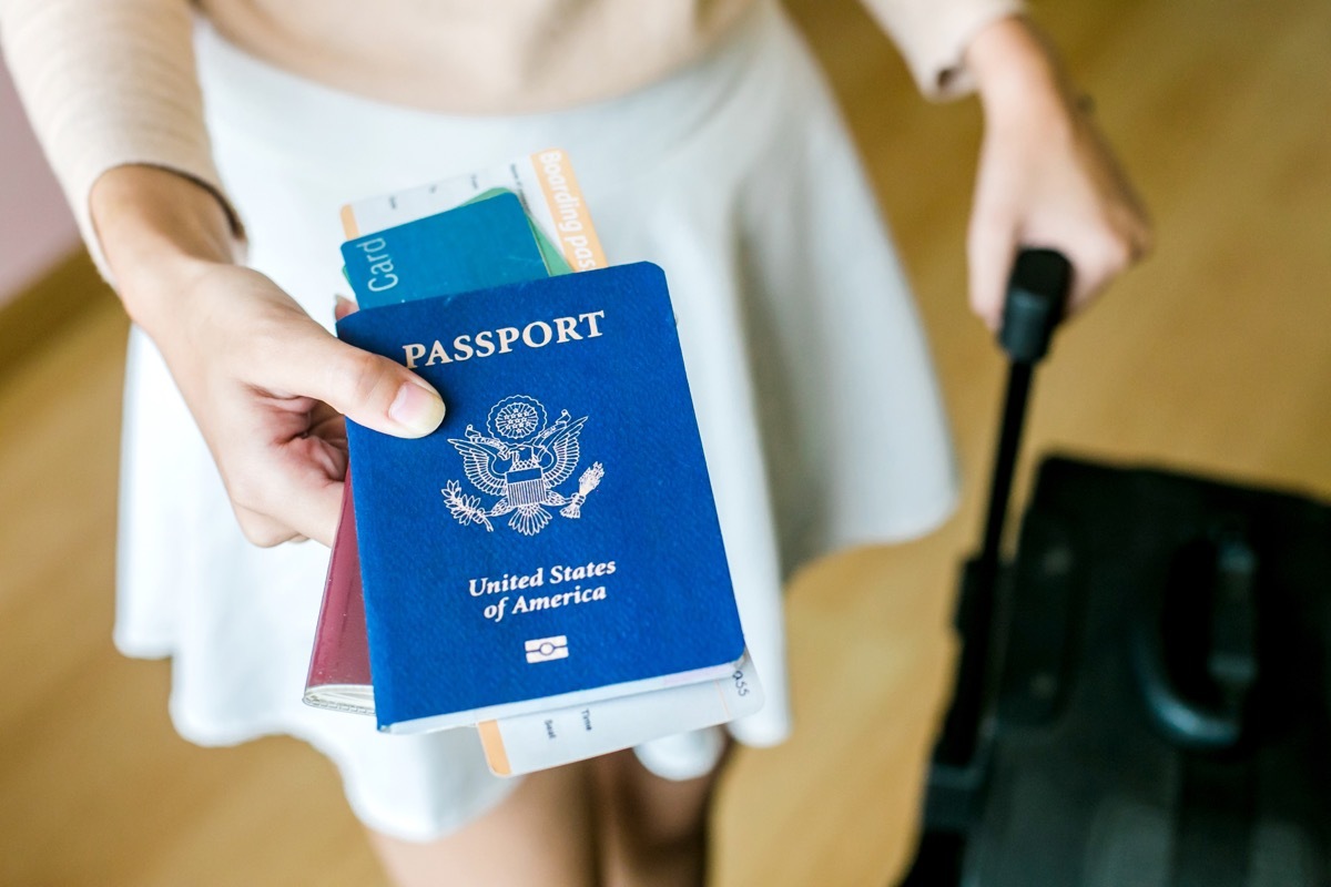 woman handing over travel documents and passport