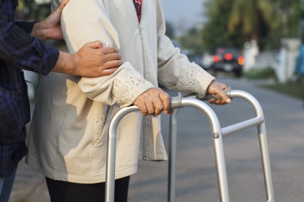 man helping older woman cross the street