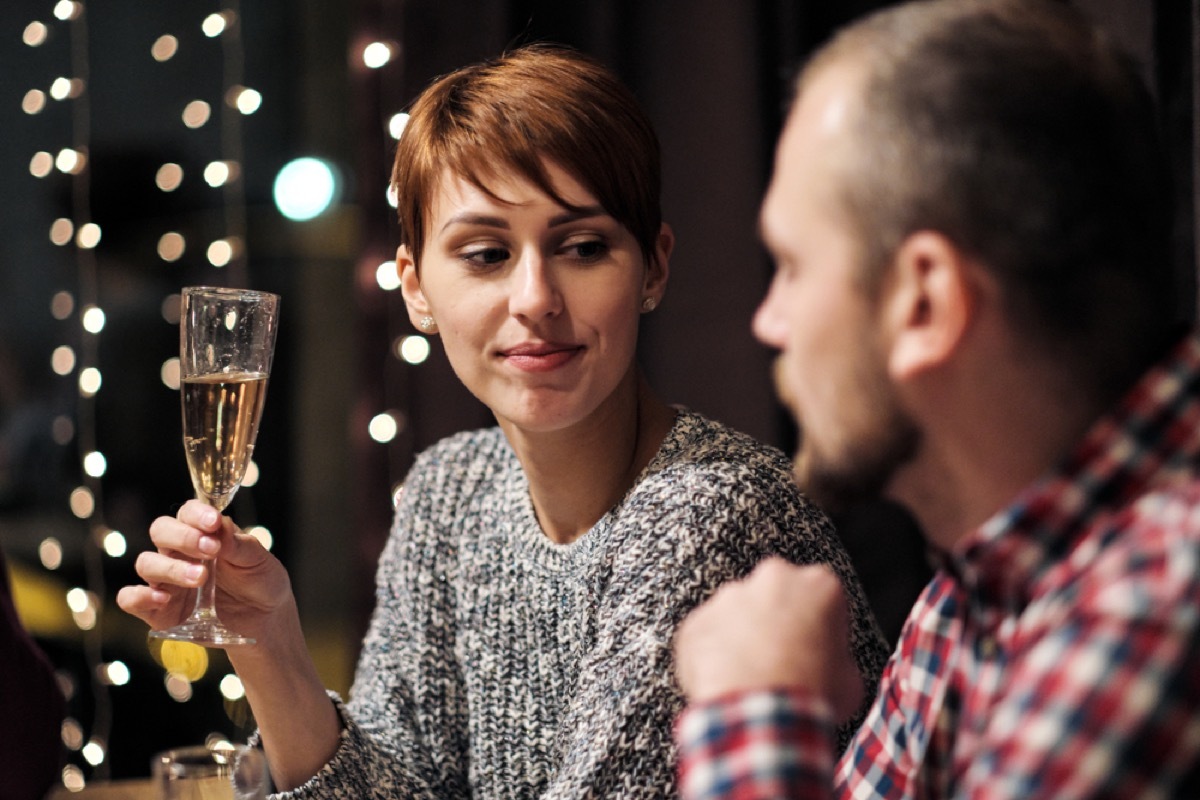 white woman looks annoyed at white man at holiday party