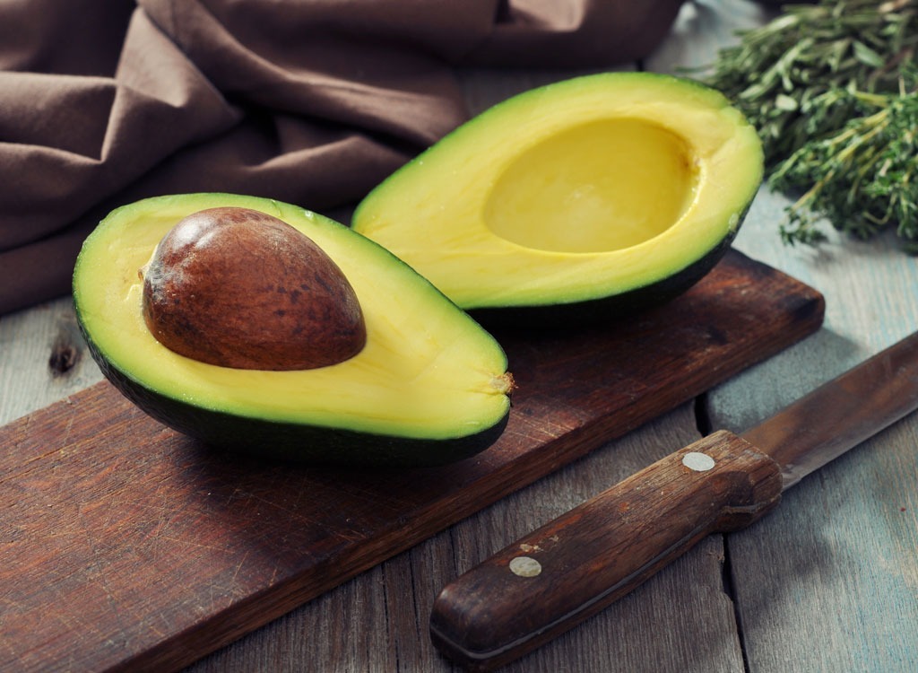 avocado on wood board with a knife