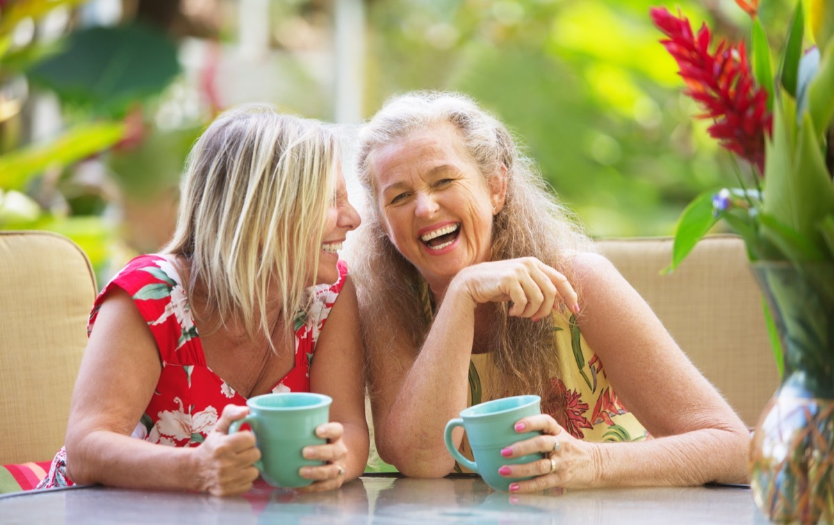 two women laughing over coffee