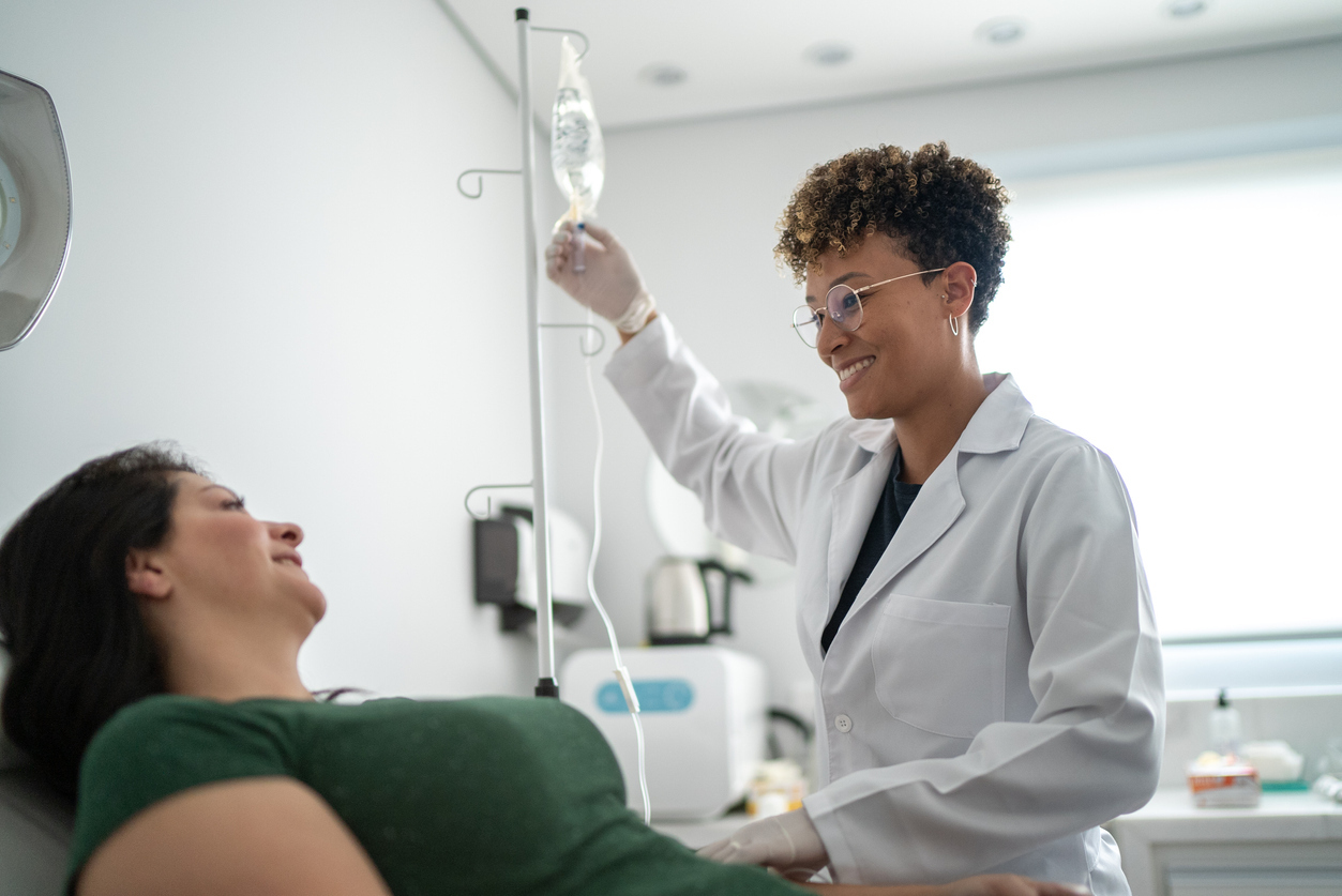 Doctor administering an IV drip to a patient.