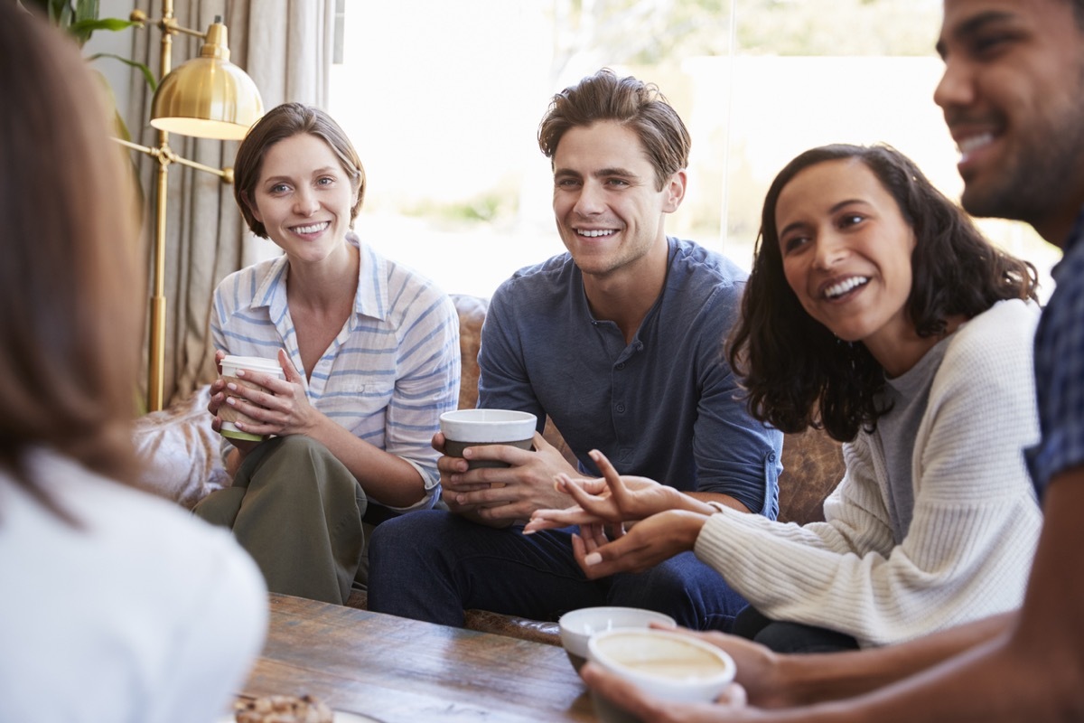 Friends relaxing around a table at a coffee shop, close up