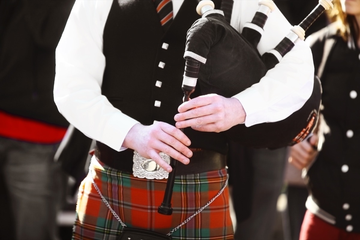 man playing bagpipes wearing a kilt