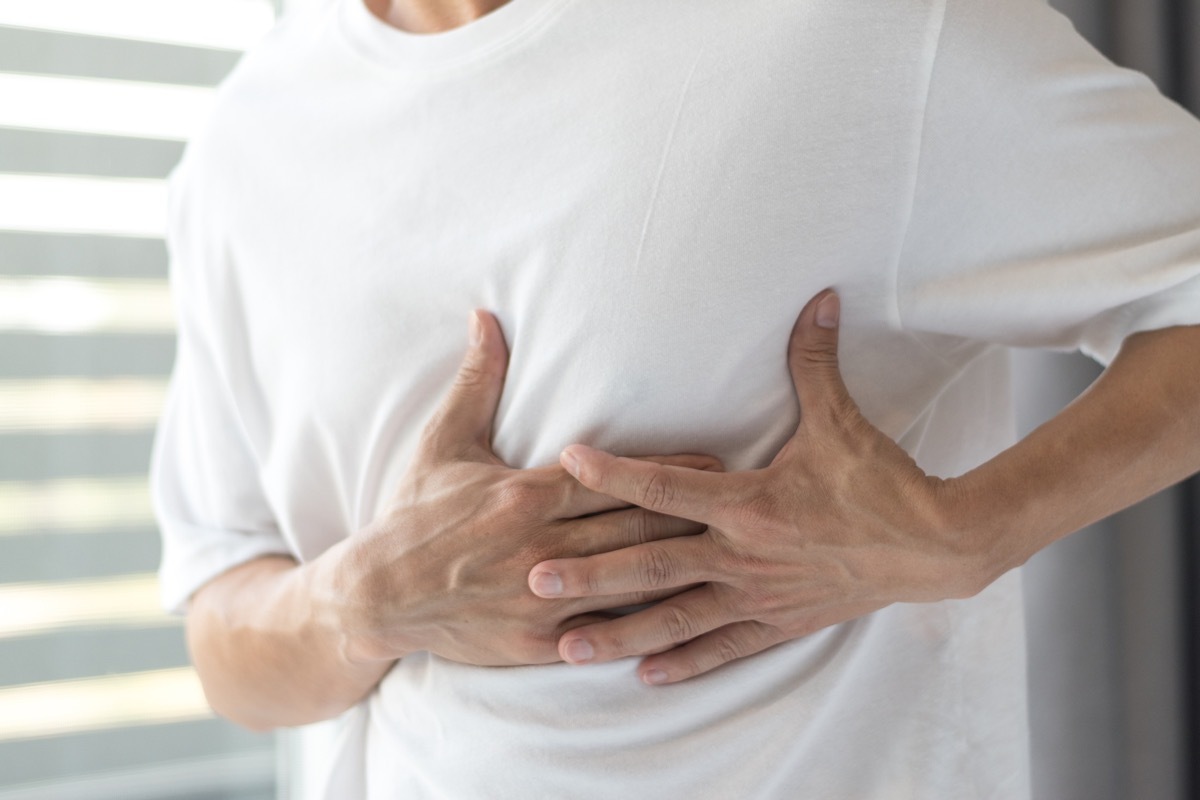 Man with hand on lungs because of discomfort