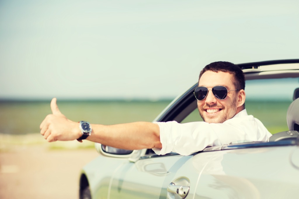 man with a thumbs up in a convertible