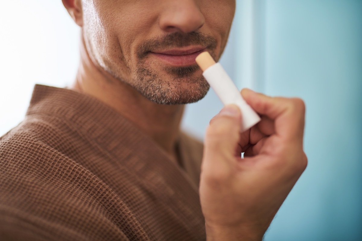 Man applying chapstick to lips