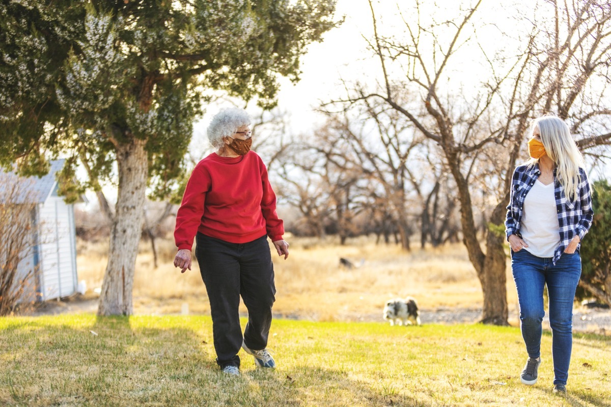 older white women walking with face masks six feet apart