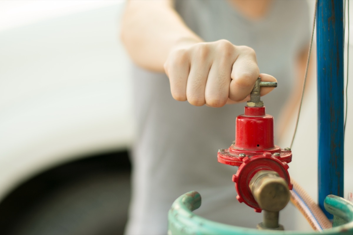 Woman's hand turns knob off water valve