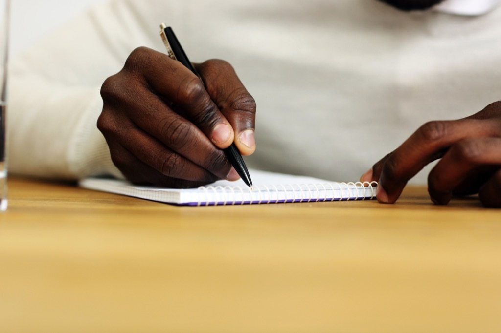 Man writing in journal happier life in 2019