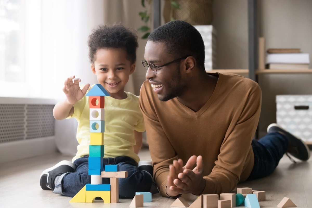 Dad playing with his toddler son being a step-parent