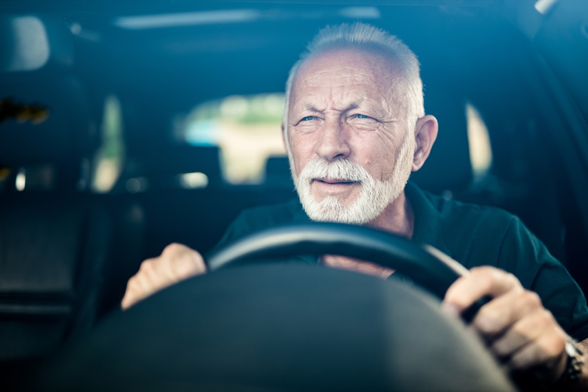 Senior man having bad eye sight and making effort to see the road.