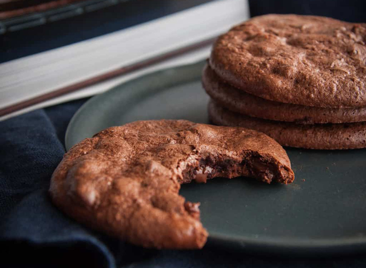 Brownie cookie with a bite in it on a dark plate