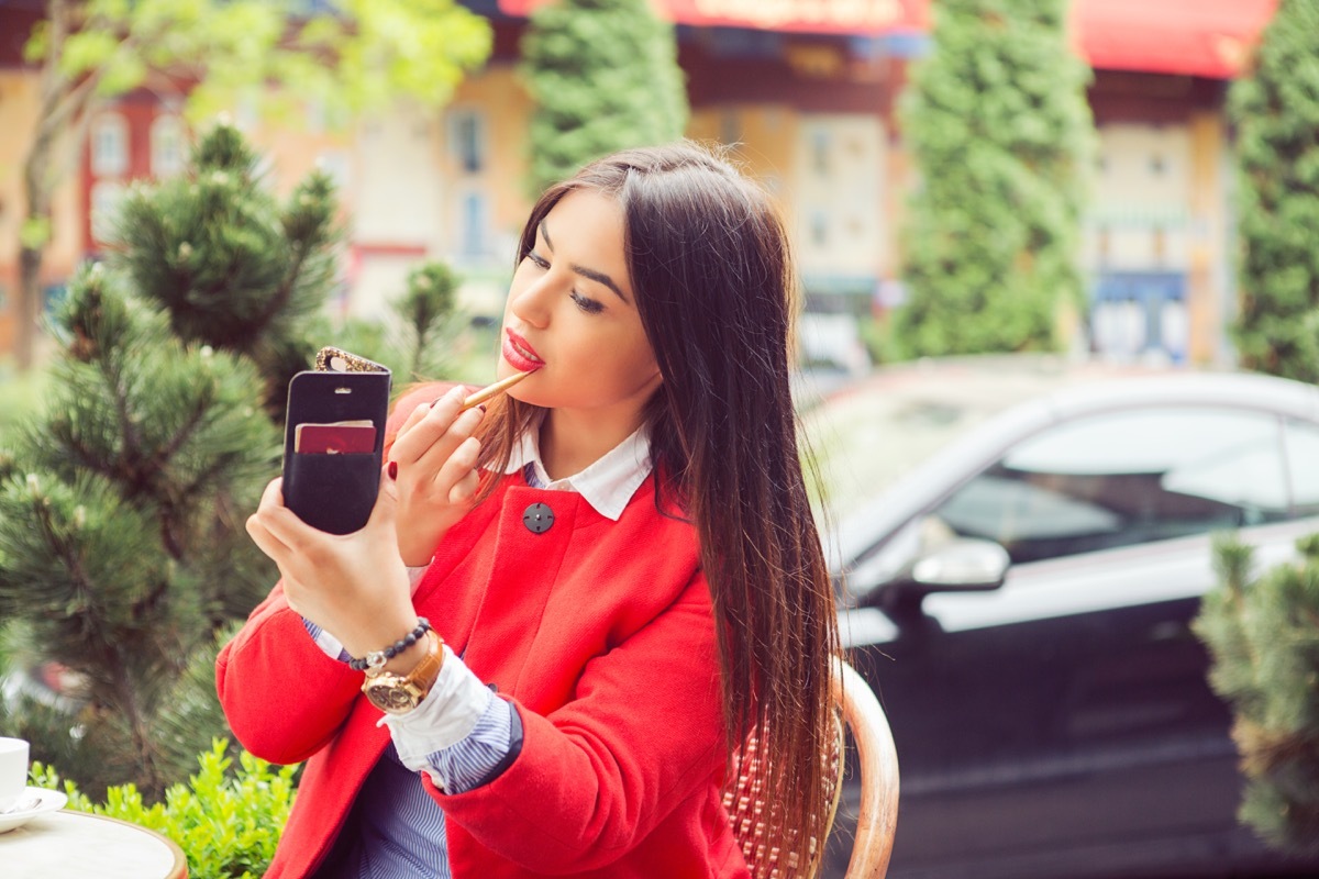 woman putting on makeup outside, summer beauty products