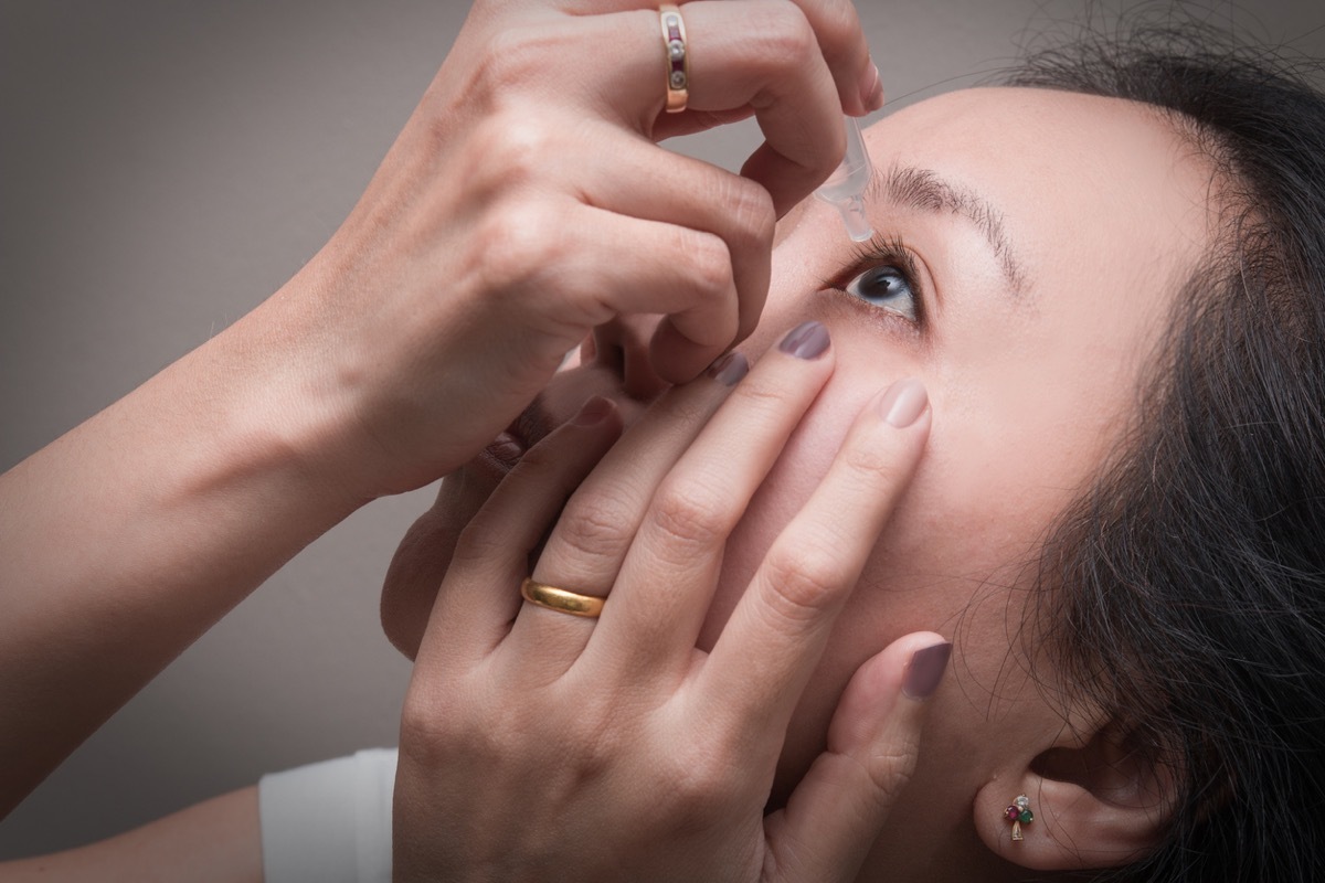 Woman putting in eye drops